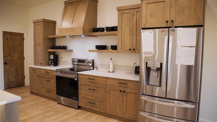 Kitchen with wood cabinets, a range hood and a French-door refrigerator