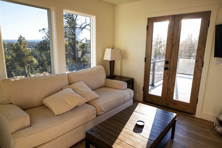 Living room with a cream sofa and French doors to a deck
