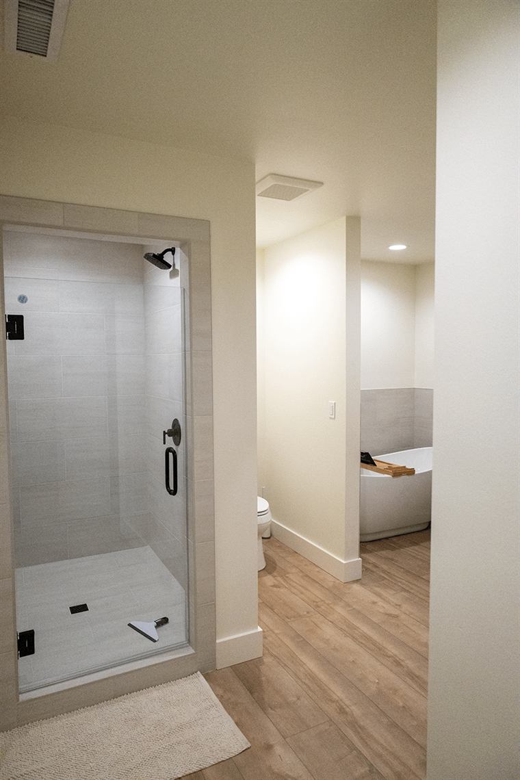Tiled walk-in shower seen through a doorway