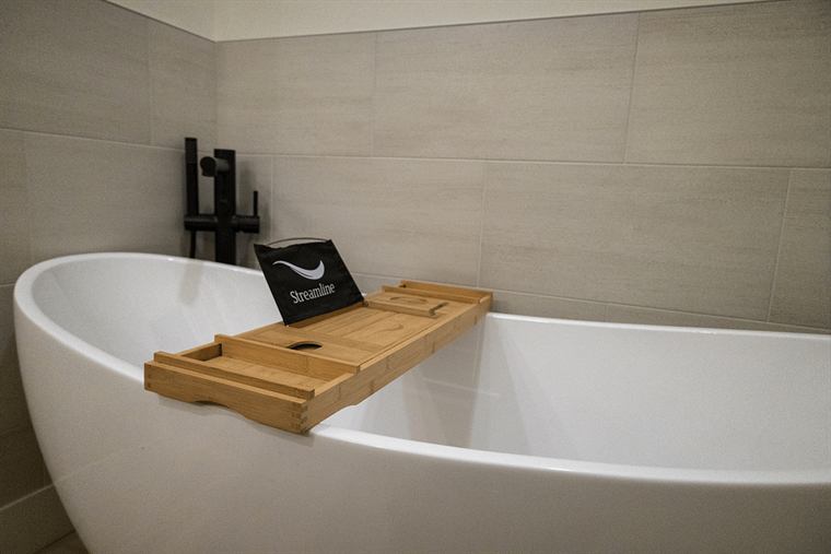 Freestanding soaking tub with a bamboo bath tray