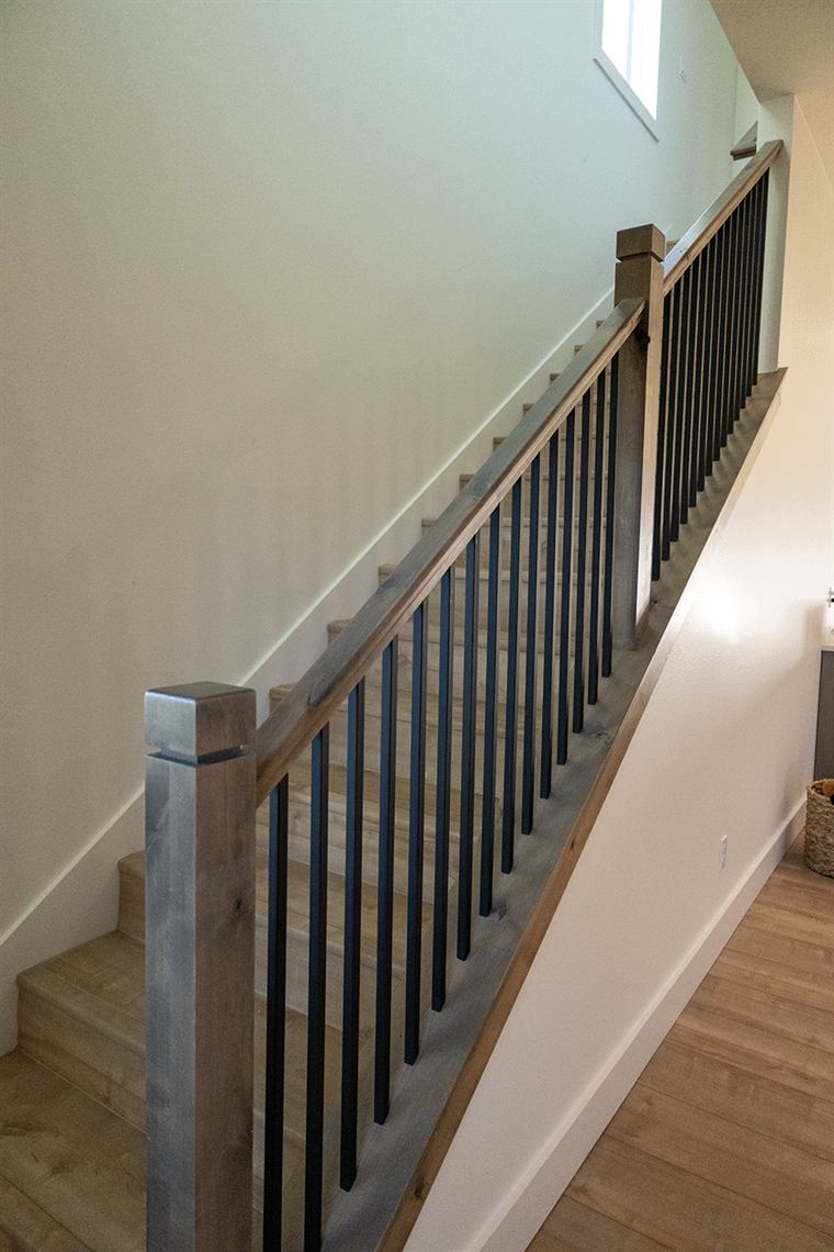 Staircase with a wood handrail and black metal balusters