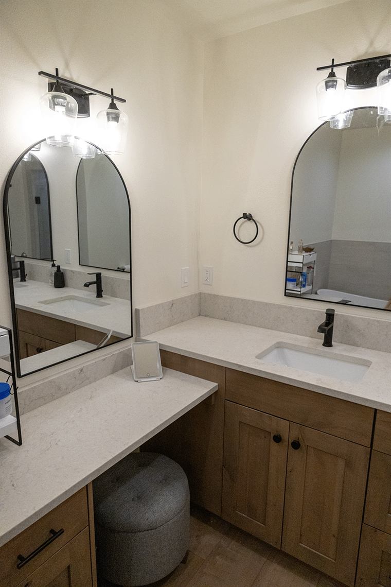 Double vanity with arched mirrors and black fixtures
