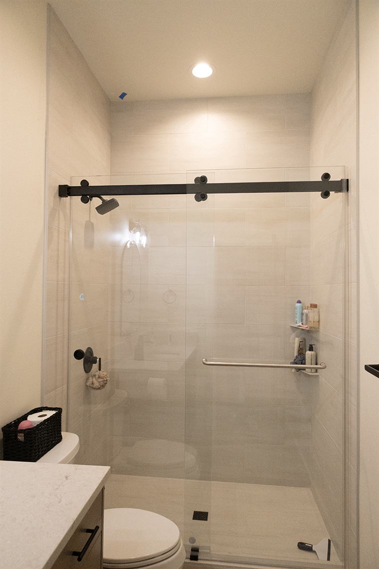Glass-door shower with black sliding hardware