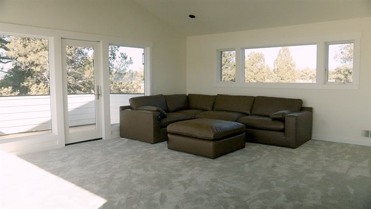 Living room with new carpet, a sectional sofa and large windows