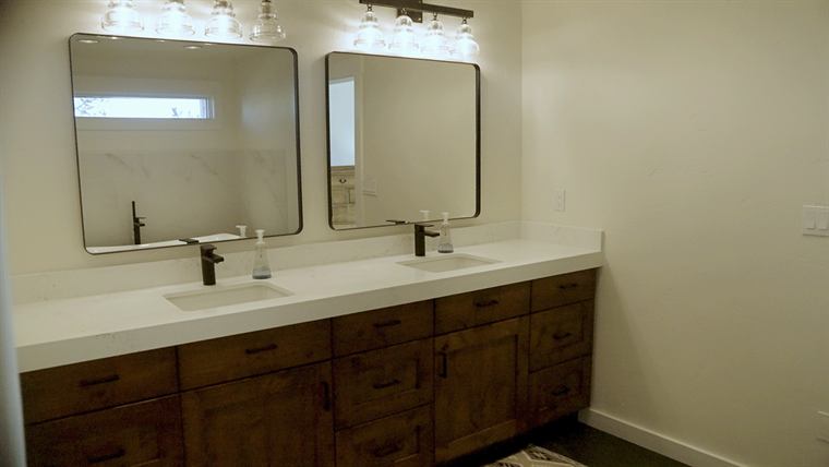 Bathroom with a double vanity, dark wood cabinets and two mirrors
