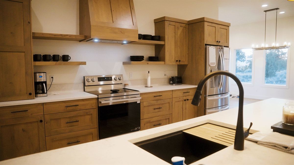 Finished kitchen with warm wood cabinets, quartz counters and stainless appliances