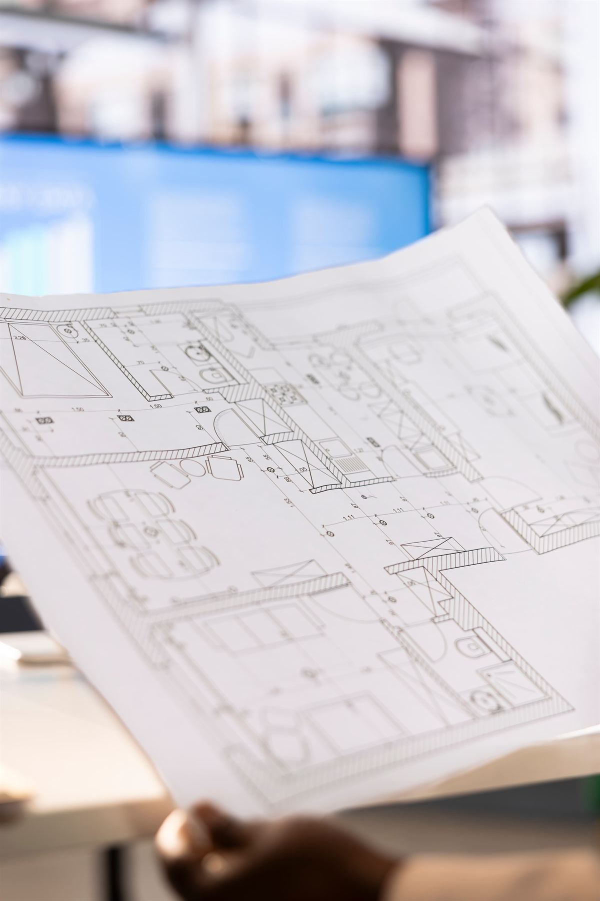 Hands holding a set of architectural floor plans