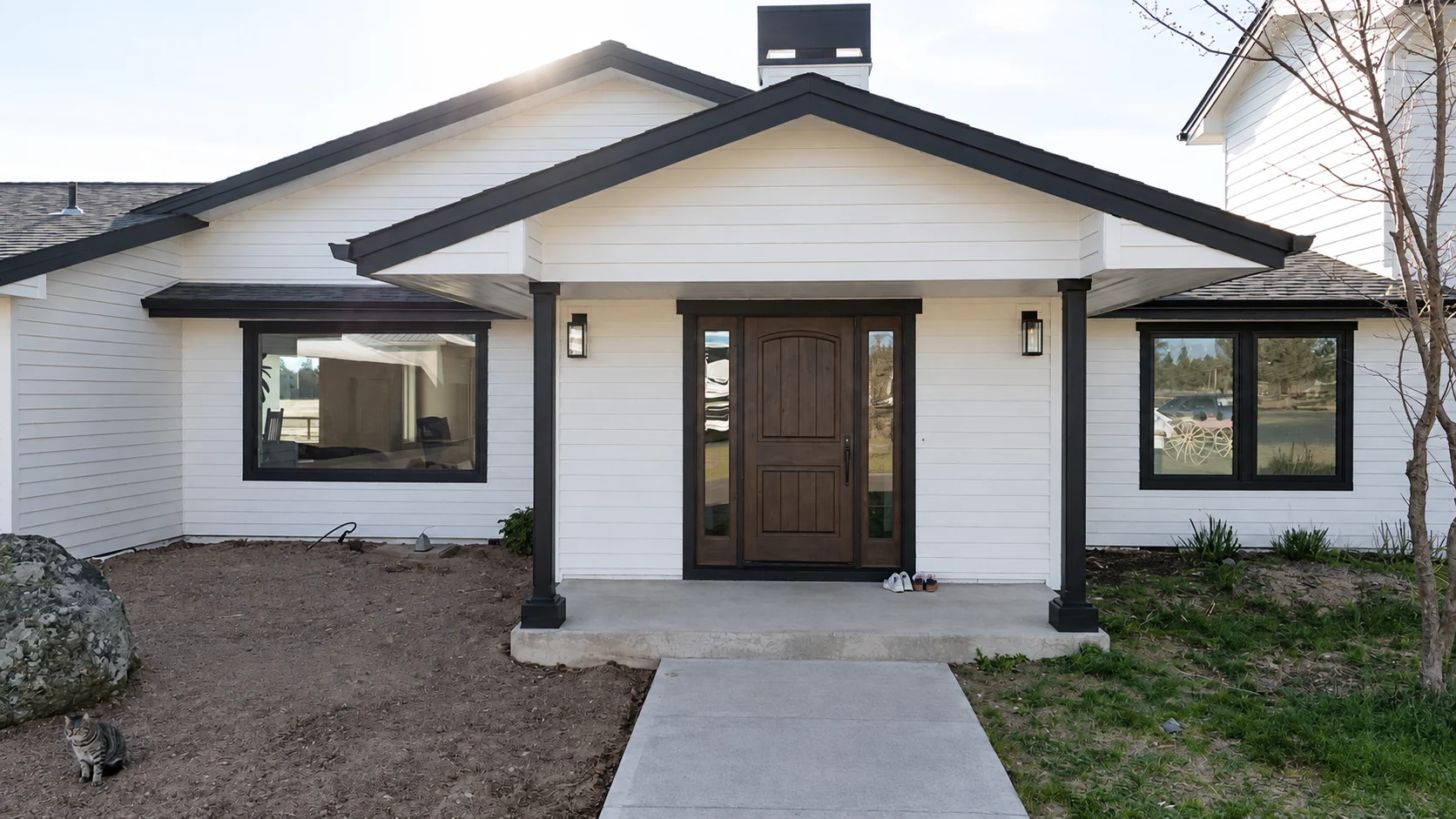 White ranch house with a new wood front door after remodeling