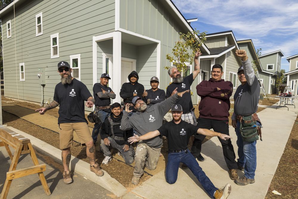 The High Desert Homes crew in matching shirts in front of a new home