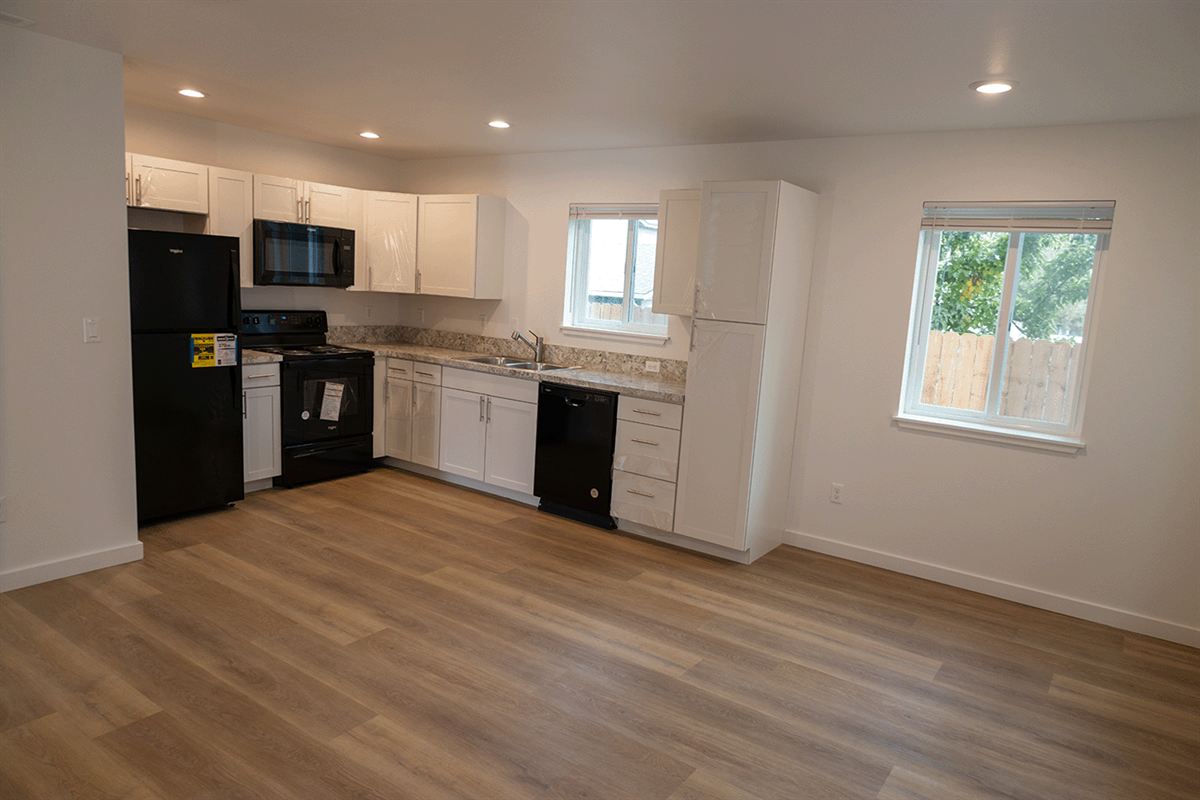 New kitchen with white cabinets and black appliances